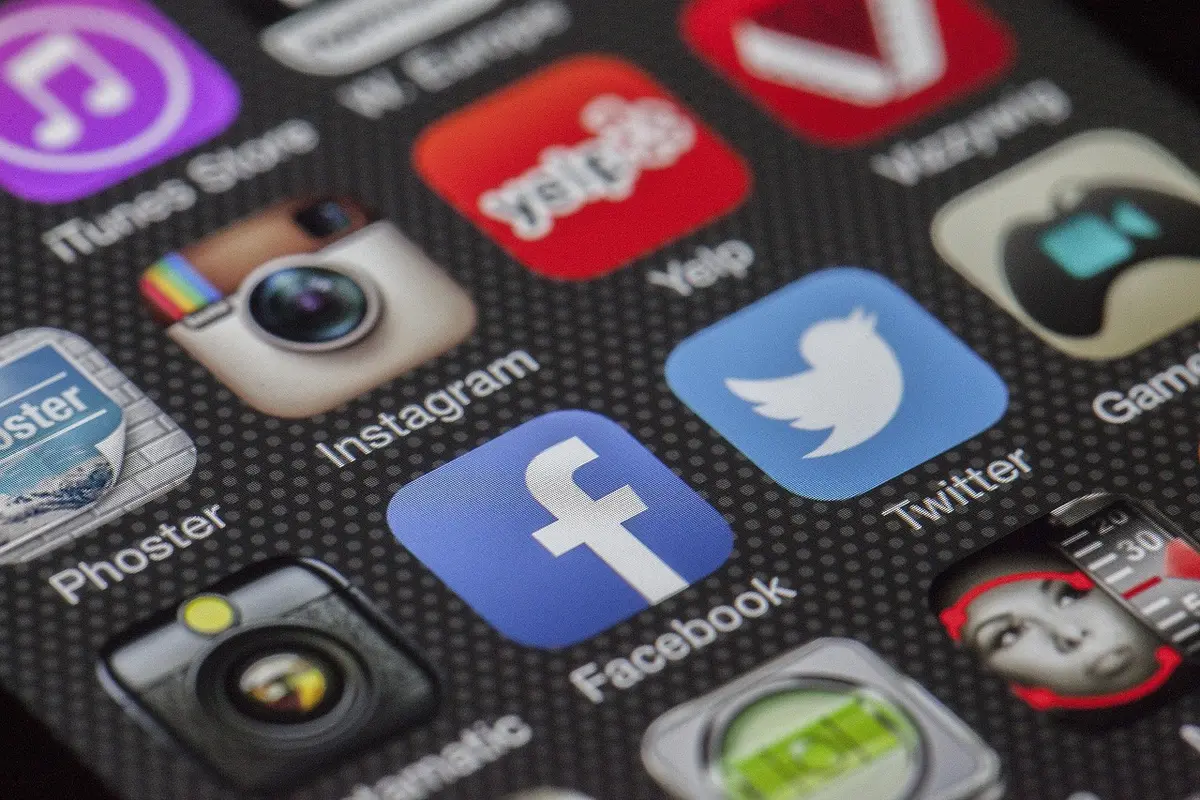 Jeune regardant un smartphone dans une chambre, illustrant les addictions numériques